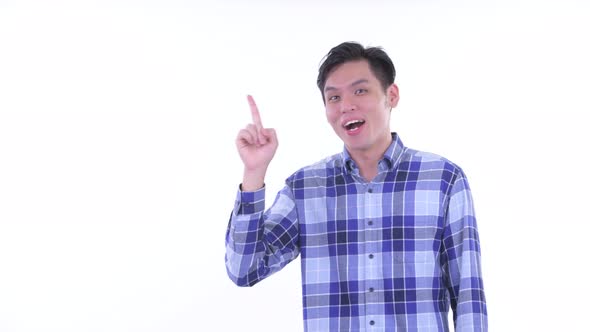 Happy Young Asian Hipster Man Talking While Pointing Up