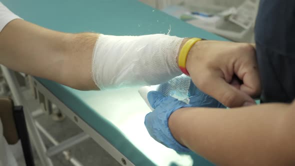 Bandage hand. Visiting traumatologist. Doctor applying bandage on the hand of the patient.