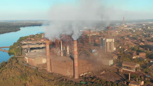 Aerial View of the Industrial Plant with Smoking Pipes Near the City. Industrial Zone