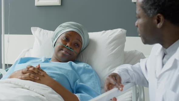 Young Female Patient Talking with Doctor in Hospital Ward