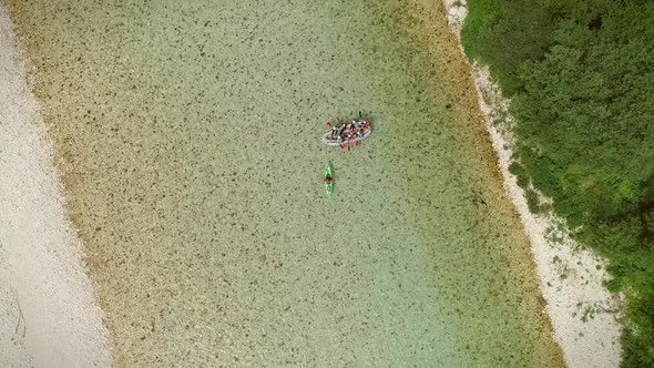 Aerial view of a group of people doing rafting turquoise and transparent water.