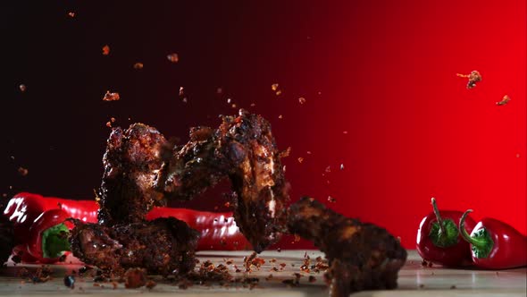 Smoked chicken wings falling and bouncing in ultra slow motion 