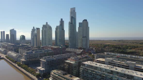 Aerial establishing shot of some Puerto Madero's skypcrapers with blue sky as background