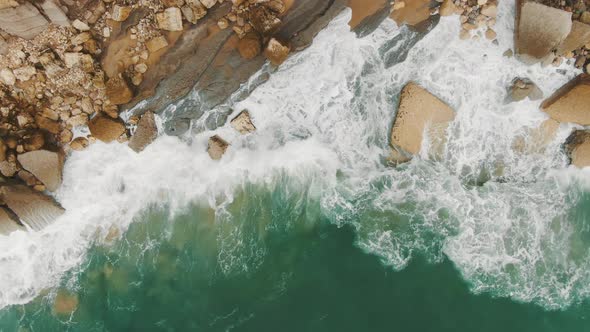 Upper View of Ocean Waves Beating Against Rocky Coast