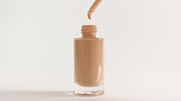 Foundation for Face Concealer Cosmetic Liquid Foundation Drips From a Pipette Into a Bottle