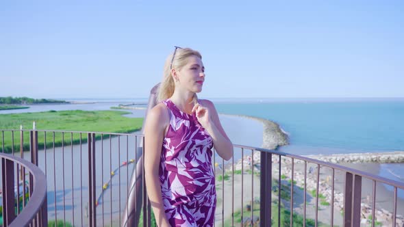 Happy Blonde Woman Walks in Front of the Blue Summer Sea