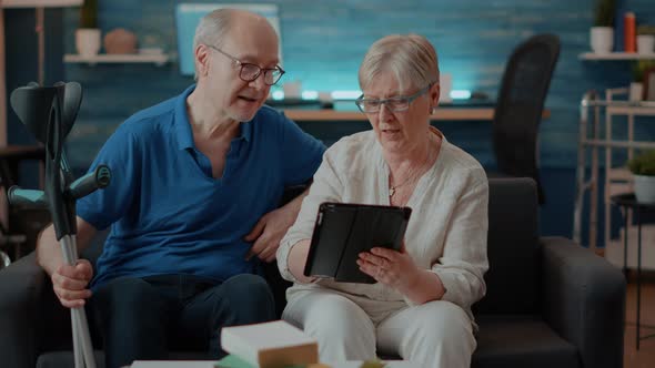 Elder Couple Looking at Tablet Screen in Living Room