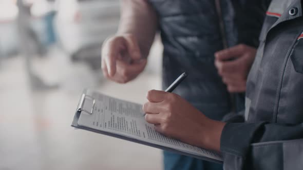 Unrecognizable Female Auto Mechanic Filling Document