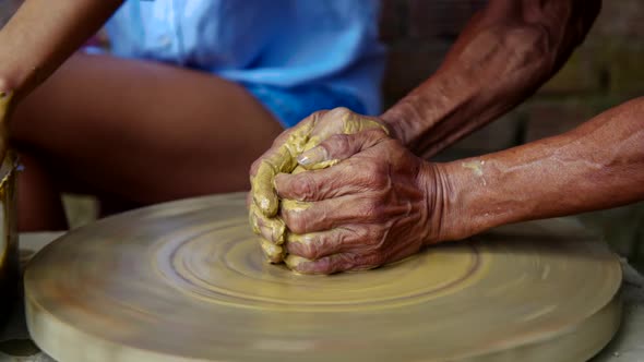 Hands of Experienced Master Make Clay Pot on Potter Wheel
