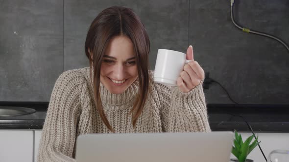 Happy Young Woman Laughing at Funny Streaming Movie on Laptop or or Is in Correspondence at Home