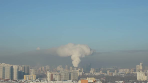 City Pipes Emit Steam Into the Arctic Atmosphere Against the City Skyline