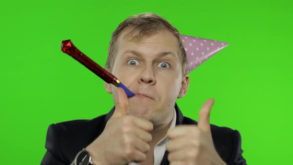 Drunk Sleepy Young Businessman with Hangover in Festive Cap Giving Thumbs Up