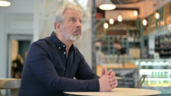 Pensive Old Man Thinking in Cafe