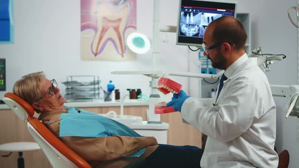 Doctor Explaining Using Mockup of Skeleton of Teeth