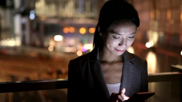 Woman use of smart phone in city at night