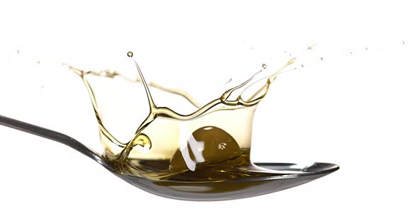 Olive Falling into Olive Oil against White Background, Slow Motion 4K