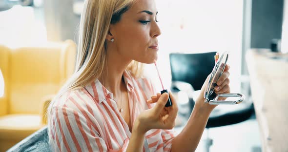 Young Beautiful Woman Applying Make Up Using Small Mirror