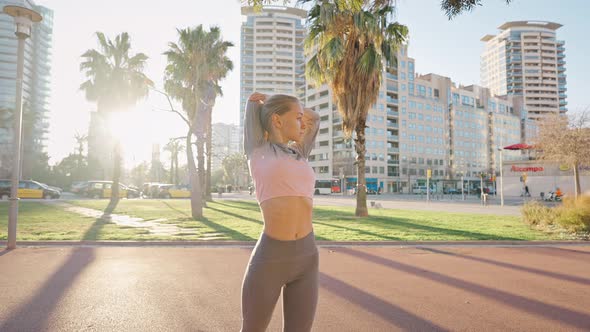 Young Woman in Sportsuit Stand on Street Do Stretching Exercises