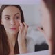 Woman Applying Eye Cream and Smiling - VideoHive Item for Sale