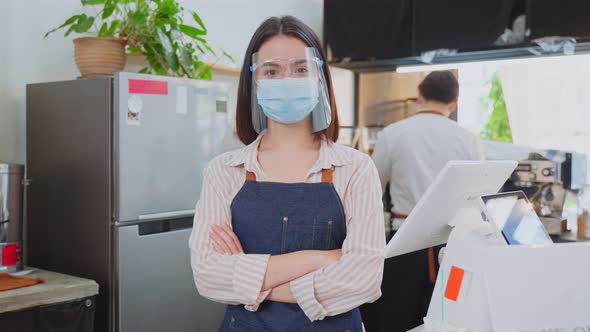 Portrait of Caucasian waitress wear mask and shield due to Covid-19 pandemic at cafe look at camera.