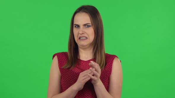 Portrait of Tender Girl in Red Dress Is Clapping Her Hands with Dissatisfaction. Green Screen
