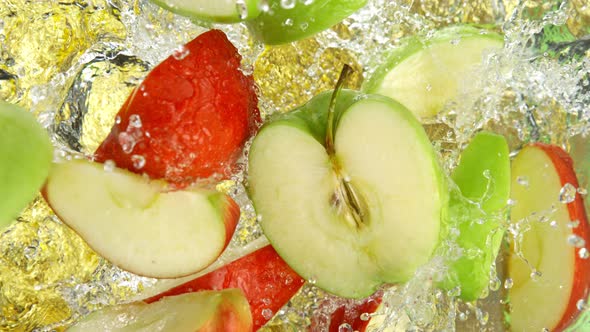 Super Slow Motion Shot of Red and Green Apple Cuts Falling and Splashing Into Water at 1000Fps