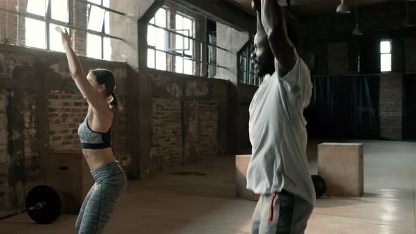 Fitness, Fit couple doing jumping jack exercise at gym indoors