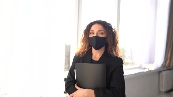 Sunny Portrait of a Curly Girl Taking Off Her Mask