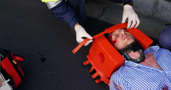 Emergency medical technician protecting the head of his wounded person