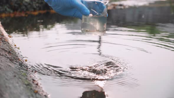 Close up the hand of Scientist took a sample of water for analysis. Environment Issue concept