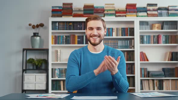 Applauding teacher by video call with a student against the background of shelves