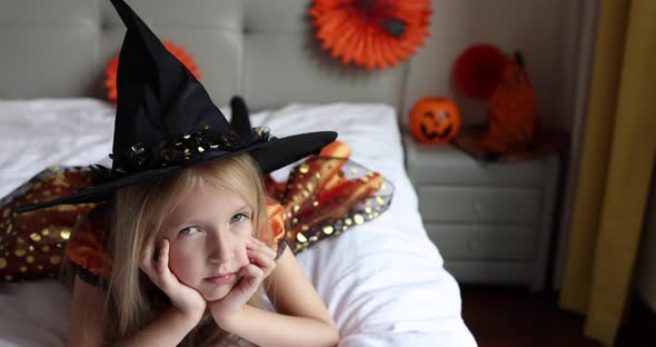 Cute Caucasian Little Girl with Blonde Hair Seven Years Old in Witch Dress and Hat Celebrating