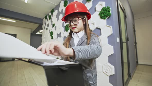 Girl Dressed As CEO Approving Plans in an Office