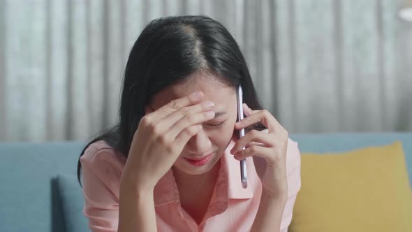 Close Up Of Asian Woman Answering The Call Then Having Headache While Looking At The Bill In Hand