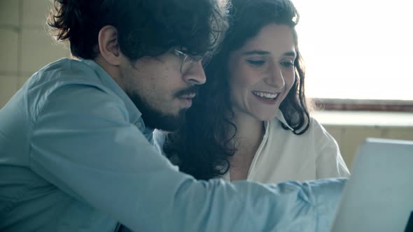 Closeup Shot of Smiling Young Colleagues Working with Laptop