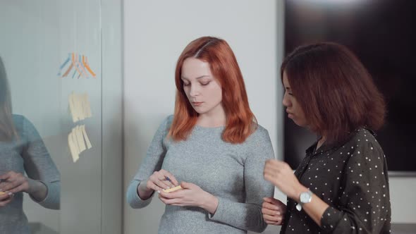 Female Colleagues Working on Project Management Strategy with Scrum Board