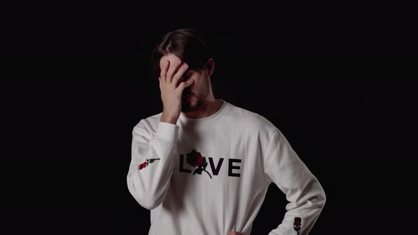 Trendy Young Man shaking head, giving facepalm gesture, wide, black background