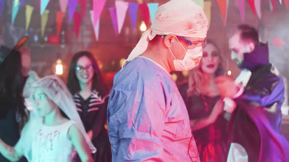 Slow Motion Shot of a Man in Psycho Mad Surgeon Costume at a Halloween Party