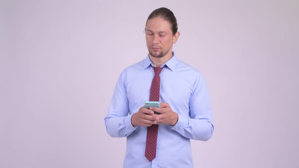 Happy Handsome Businessman Thinking While Using Phone