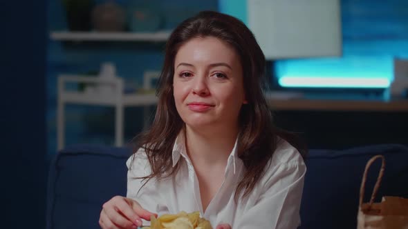 Portrait of Young Woman Sitting in Living Room Eating Snack