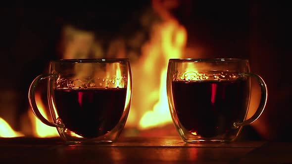 Glass Cups with Tea on the Background of the Fireplace