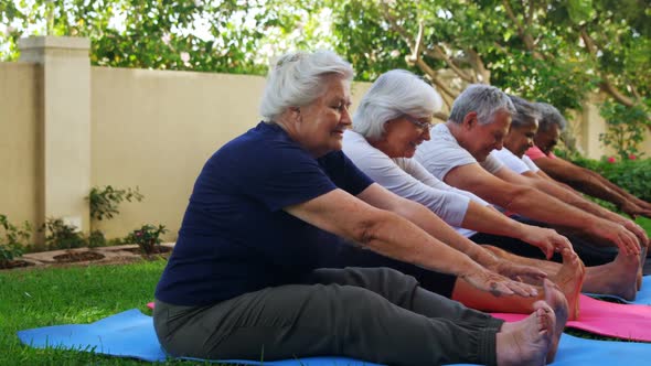 Senior friends doing stretching exercise in garden 4k