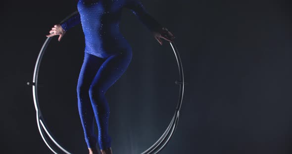 Professional Gymnast is Performing in the Studio in Low Lighting Spinning Hoop