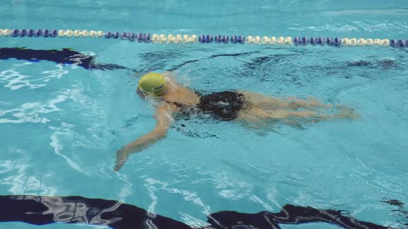 Side View Of Mature Woman Doing Breaststroke In Swimming Pool