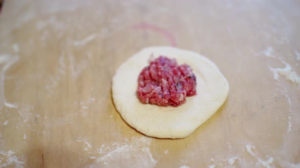 Fork Put the Meat Filling Into a Round Rolled Dough for a Patty