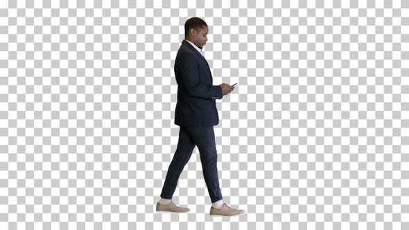 Young African American man walking and texting, Alpha Channel