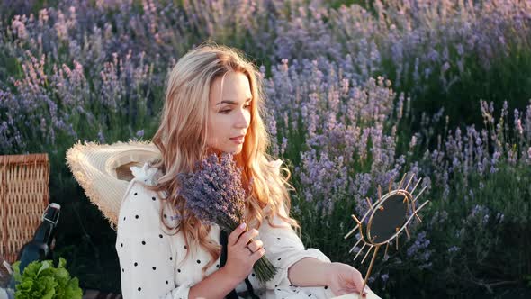 Pretty Blond Woman in a Dress Sitting in the Lavender Field