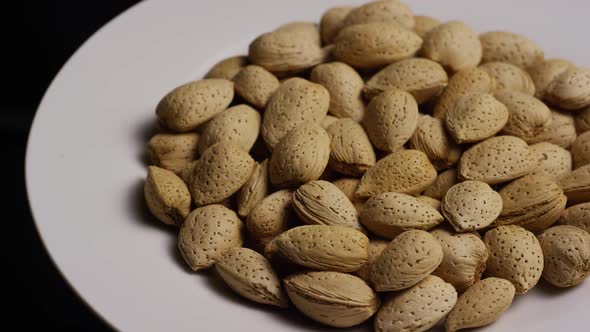 Cinematic, rotating shot of almonds on a white surface - ALMONDS