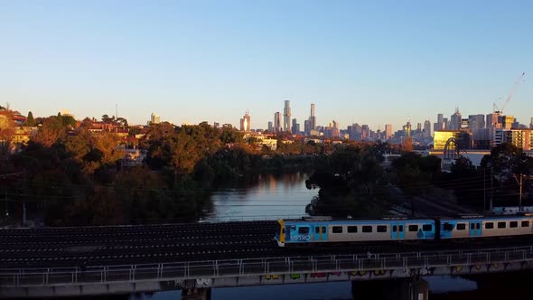Drone of the sweeping Melbourne skyline as a train passes by - Australia.