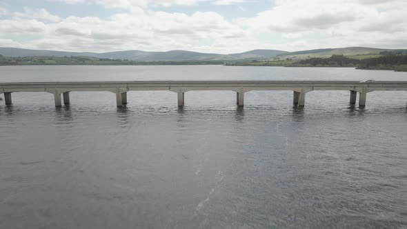 Cars Crossing Blessington Lake Through Road Bridge In County Wicklow, Ireland. aerial drone pullback